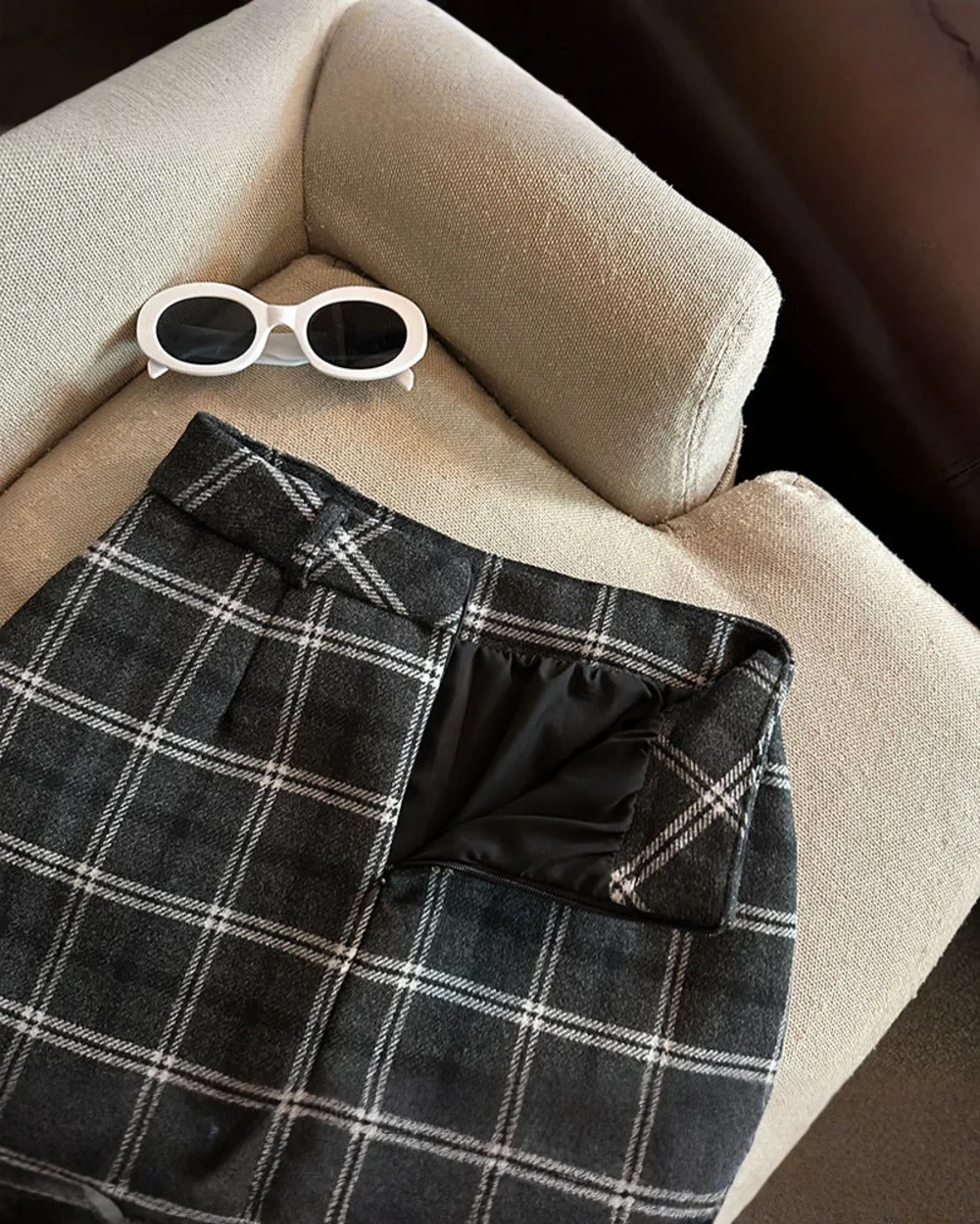 Close-up of a grey and white plaid mini skirt, embodying a preppy aesthetic skirt style.