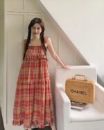 French vintage suspender skirt worn by a woman, featuring a tiered plaid design.