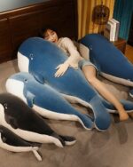 Two kawaii whale plushies, Bubbles and Luna, displayed with a person. One is blue and large, the other is black and smaller.