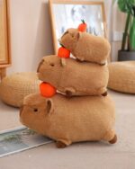 Two brown capybara plushies, one stacked on the other, with orange carrot accessories.