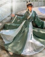 Jade Ruqun Hanfu Long Dress: A flowing green and white traditional Chinese garment worn by a woman outdoors.