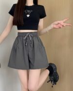 Woman wearing elastic casual shorts, Korean aesthetic shorts, with a crop top and accessories.