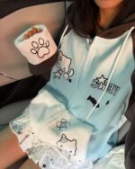 Kawaii Neko hoodie featuring a cat face and paw print design on a light blue zip-up sweatshirt.