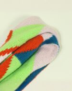 Close-up of a cute fox scarf featuring colorful geometric patterns in green, orange, and blue.