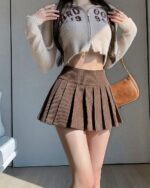 Brown vintage aesthetic mini skirt with pleats, high waist style.