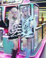 Two people wearing a Harajuku Long-Sleeved Stripped Shirt - Yami Kawaii Aesthetic in an arcade.