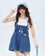 Blue kawaii denim overalls with decorative patches and bow, Y2K style.