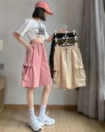 Casual Loose Shorts – Korean Aesthetic, pink and beige cargo shorts with pockets displayed on a hanger.