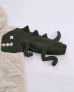Close-up of a harajuku dino hoodie featuring a plush green dinosaur applique on a beige fleece.
