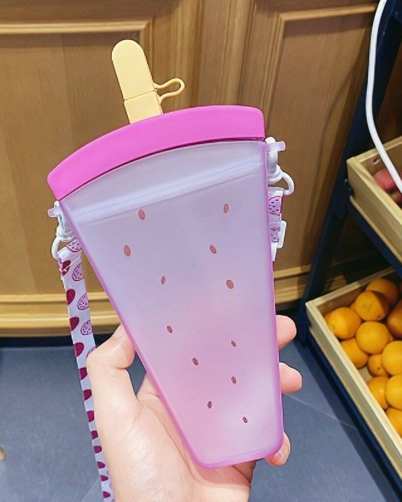 Pink kawaii fruit bottle shaped like a popsicle, featuring a handle.