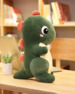 Green kawaii dino plushie sits on a desk, perfect for aesthetic room decor.