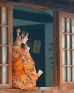 Woman wearing a flower summer yukata, traditional Japanese garment, with intricate floral design.