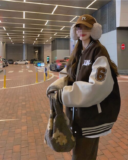 Woman wearing a brown and white korean aesthetic jacket with varsity details.