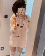 White kaomoji bear hoodie worn by a person in a mirror selfie.