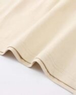 Close-up of beige kitten besties t-shirt fabric.