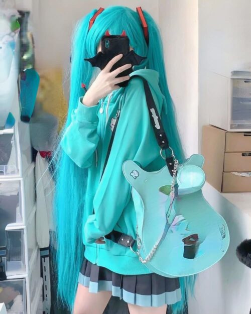 Model wearing a turquoise harajuku hoodie and crossbody bag.