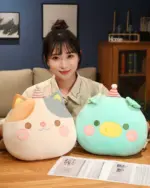 Round animal hand warmer plushies, including a cat and a duck, with hats and decorative details.