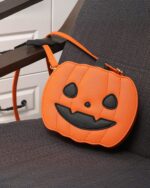 Cute orange pumpkin halloween bag with a smiling face and black details.