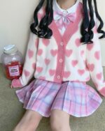 A kawaii knitted sweater with heart details, worn by a young person.