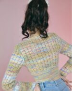 Back view of a vintage aesthetic sweater, a hollow-out knitted long-sleeved top in a pastel color palette.