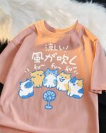 The Wind Blows Cool cat and dog tee featuring cartoon cats and dogs with a fan design.