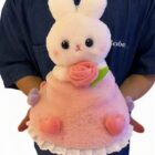 Close-up of a white and pink bouquet rabbit plushie with rose details, a cute gift.