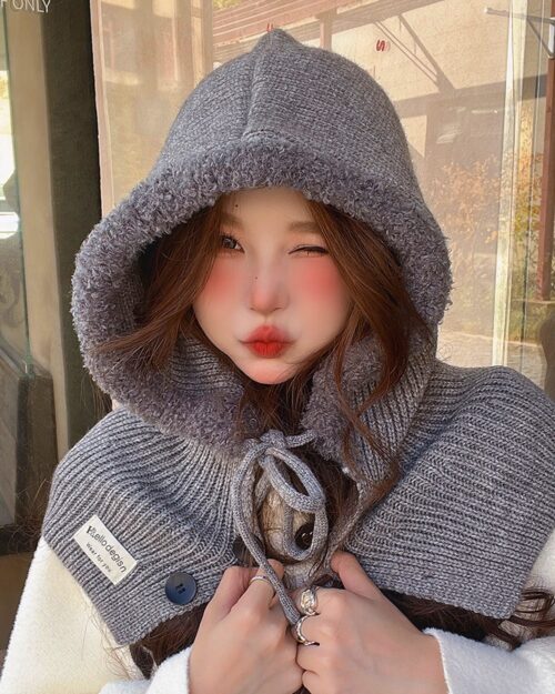 Close-up of a gray Korean balaclava hat worn by a woman, featuring a hood and ties.
