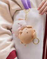 Close-up of a kawaii piggy keychain plushie, two adorable plush pigs hanging on a keyring.