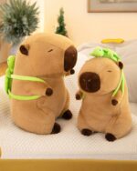 Two plush capybara backpacks from the Turtle Collection, featuring small turtles strapped on their backs.