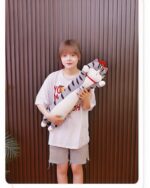 Woman holding a long cat plushie, Whiskers the Stripped Emperor Cat