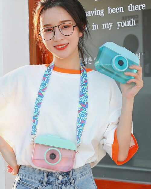 A cute kawaii camera bottle with a strap, held by a person.