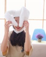 A white kawaii bunny ears hat worn by a woman.
