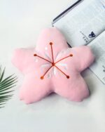 Pink cherry blossom pillow with embroidered star details, kawaii decor.