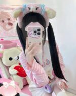 A person wearing a kawaii striped shirt and plush toys.