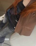 Close-up view of low waist y2k jeans, featuring a casual outfit with a leather vest.