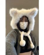 Close-up of a white fox ears hat worn by a person.