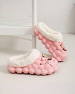 Pink fluffy foam slippers with a plush, white lining and waffle sole.
