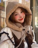 Woman wearing a beige Korean balaclava hat with faux fur trim, styled with a winter coat.
