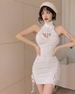 White hollow-out mini dress with a high neck and tie details.