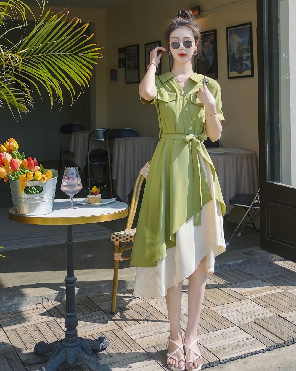 French vintage dress in a light green hue, featuring a belted waist and asymmetrical hemline, worn by a woman.