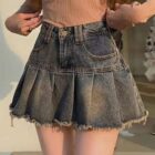 Gray denim y2k aesthetic skirt with pleats and frayed edges.