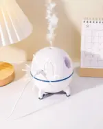 Kawaii Mini Spaceship Humidifier emitting mist on a table with a calendar.