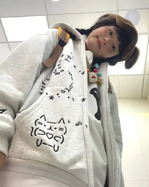 Y2K Kaomoji Hoodie featuring a cat graphic and kawaii doodles on a gray pullover.