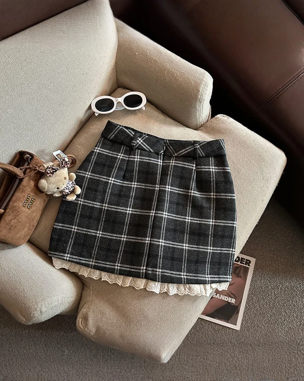 Plaid mini skirt with a preppy aesthetic, featuring a checkered pattern and layered trim.