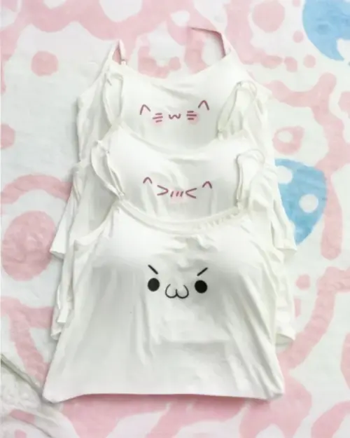 Three white cutecore aesthetic vest designs featuring kaomoji illustrations.