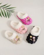Set of pink and white fluffy foam slippers with rainbow and character decorations.