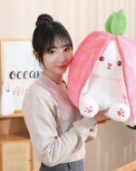 Kawaii transformable bunny plushie, featuring a carrot and strawberry design, held by a person.