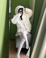 Person wearing a fluffy rabbit ears hoodie, kawaii clothes style.
