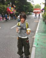 Person wearing a retro grunge t-shirt and camouflage pants outdoors.