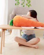 Close-up of a cute kawaii carrot plushie, soft and plush, resting on a wooden table.